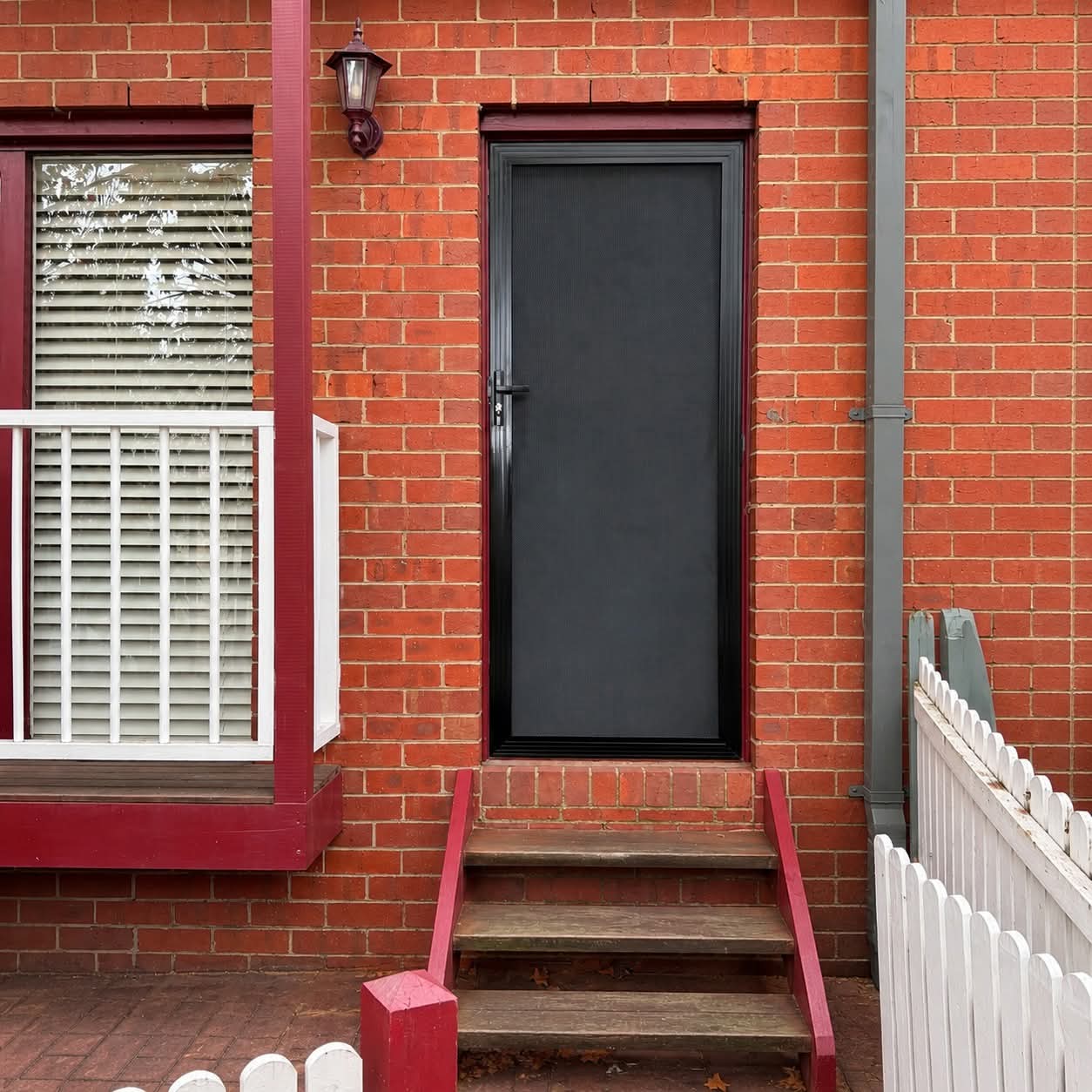 Modern black front door on a red brick exterior
