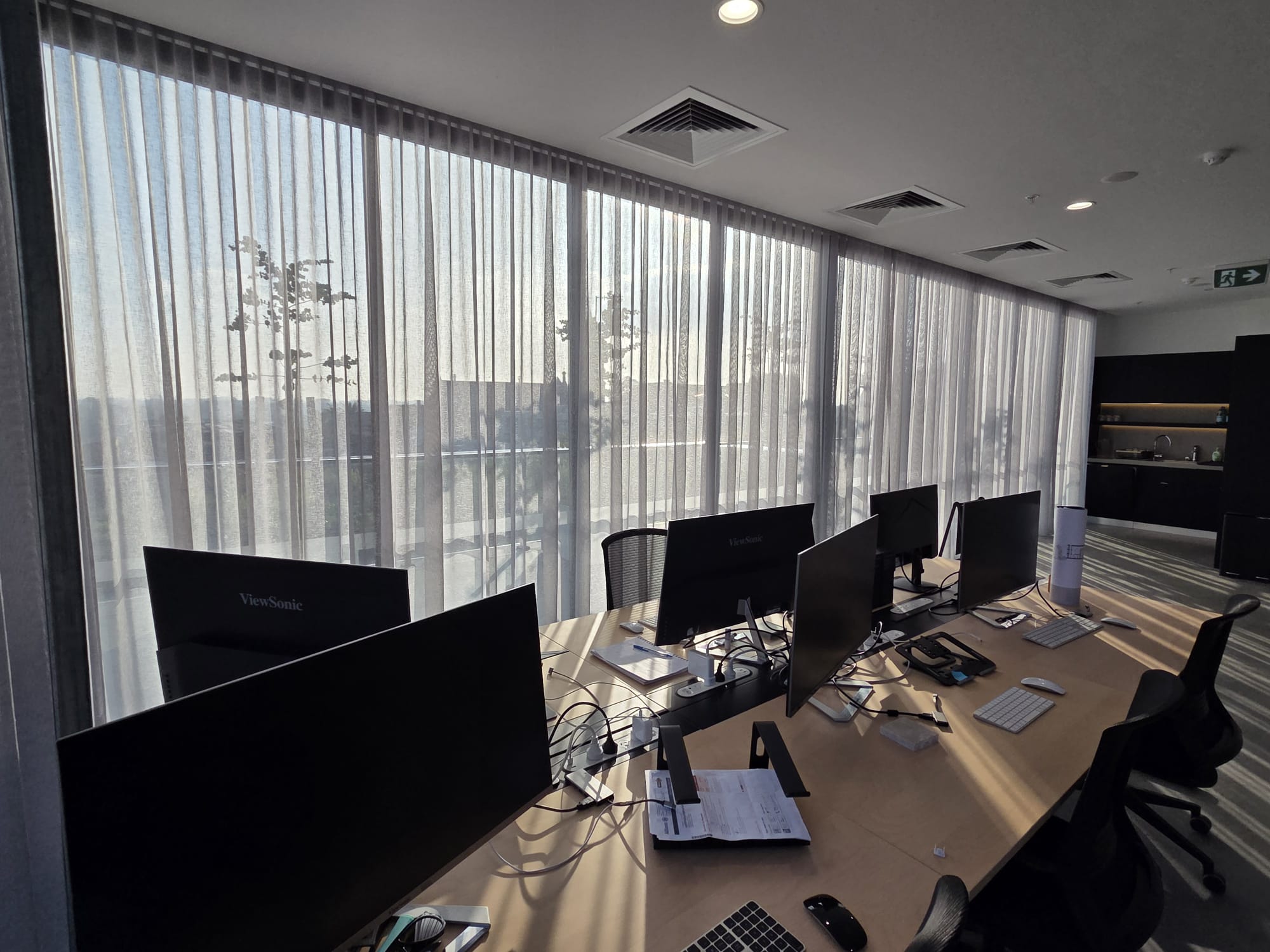 Modern office workspace with multiple computer monitors on desks