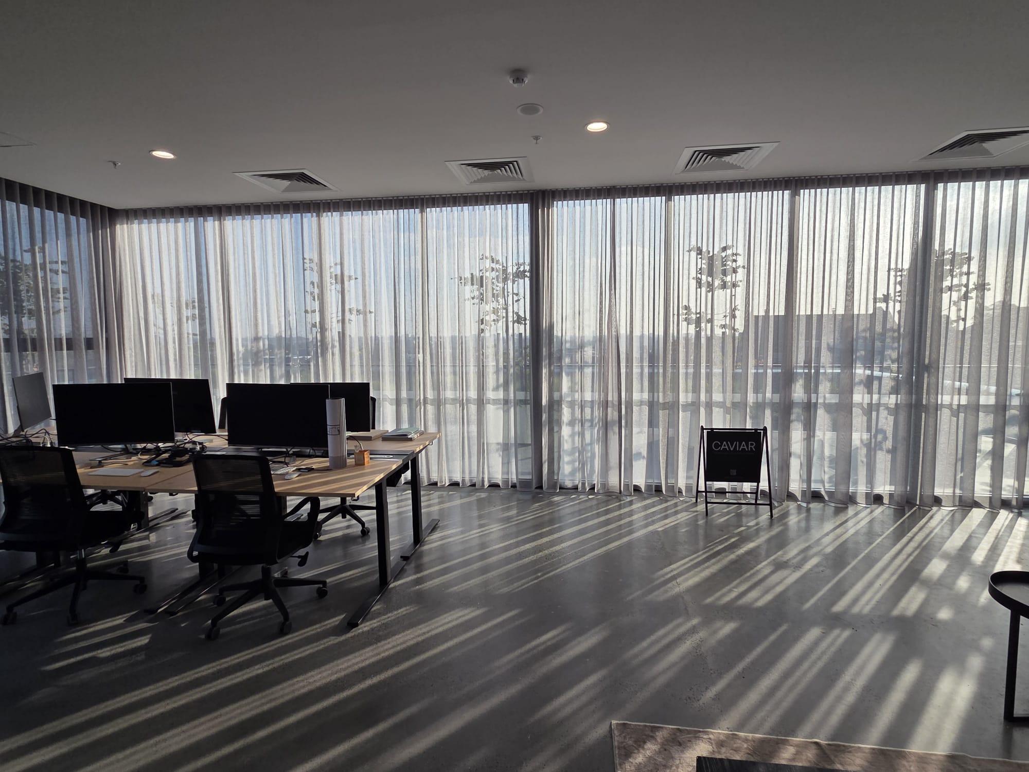 Modern office workspace with floor-to-ceiling sheer curtains